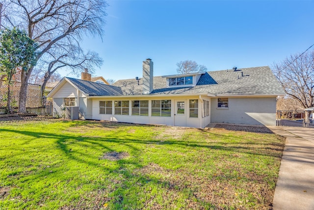 back of property featuring a yard, a sunroom, and central air condition unit