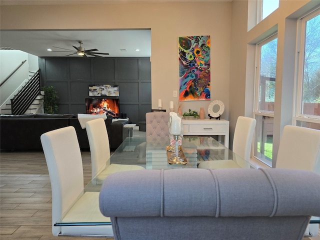 dining room featuring ceiling fan and a tile fireplace