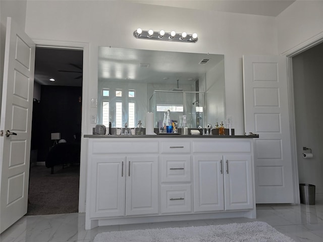 bathroom featuring vanity and a shower with door