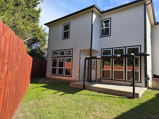 rear view of house featuring a lawn and a patio area