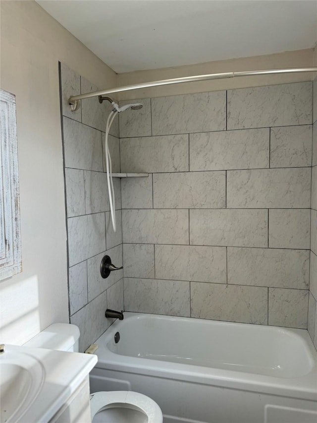 bathroom with tiled shower / bath combo and toilet