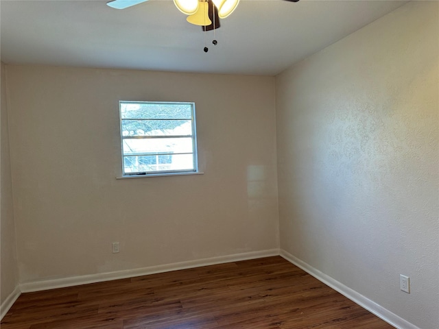 spare room featuring ceiling fan and dark wood-type flooring