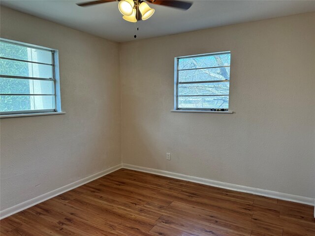 unfurnished room with ceiling fan and dark hardwood / wood-style flooring