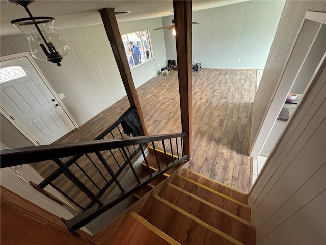 staircase with wood-type flooring and wood walls