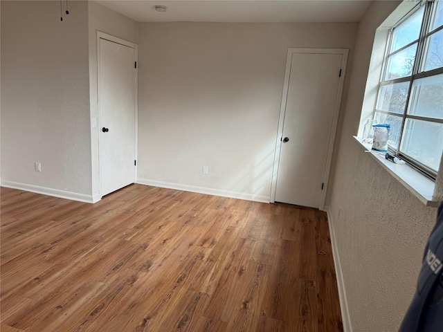 unfurnished room with hardwood / wood-style flooring