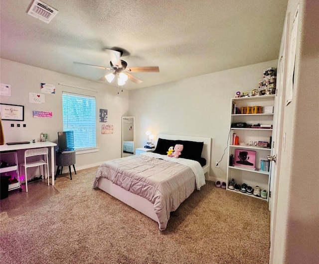 carpeted bedroom featuring ceiling fan and a textured ceiling