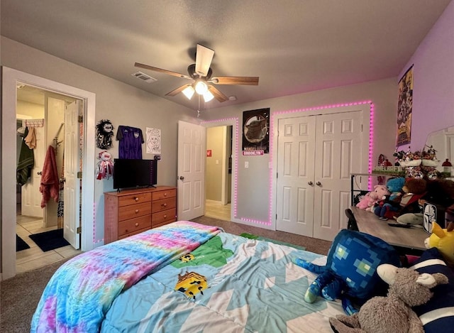 bedroom featuring light colored carpet, ceiling fan, and a closet