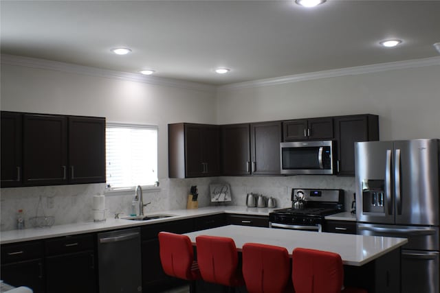 kitchen featuring sink, crown molding, a center island, stainless steel appliances, and decorative backsplash