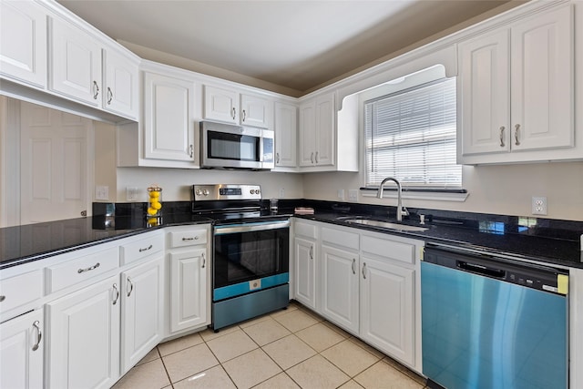 kitchen with light tile patterned flooring, sink, white cabinetry, and stainless steel appliances