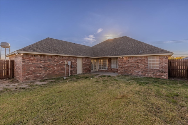 rear view of house featuring a yard