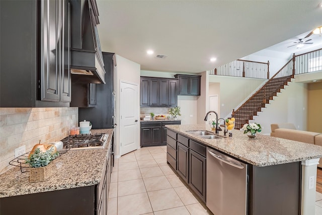 kitchen with dishwasher, a kitchen island with sink, sink, and light tile patterned floors