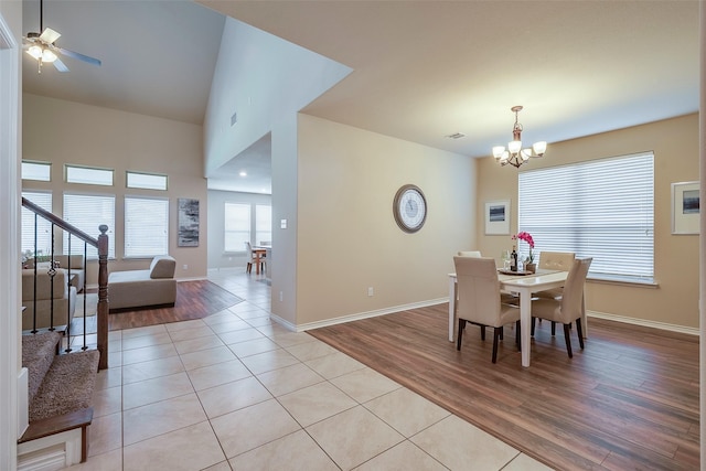 dining room with ceiling fan with notable chandelier and light tile patterned floors