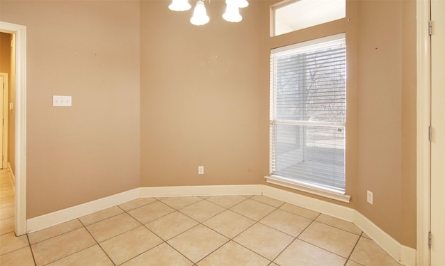 spare room with light tile patterned flooring and a notable chandelier