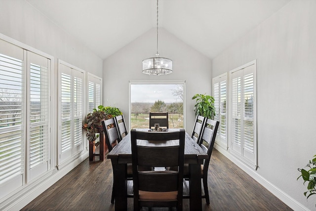 dining space featuring a notable chandelier, dark hardwood / wood-style floors, and vaulted ceiling