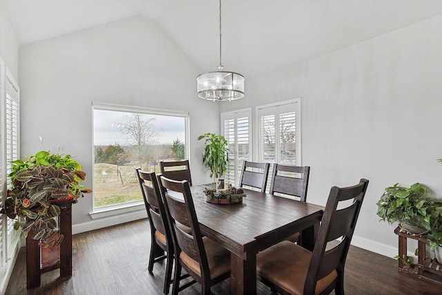 dining space with dark hardwood / wood-style flooring, a wealth of natural light, lofted ceiling, and a notable chandelier