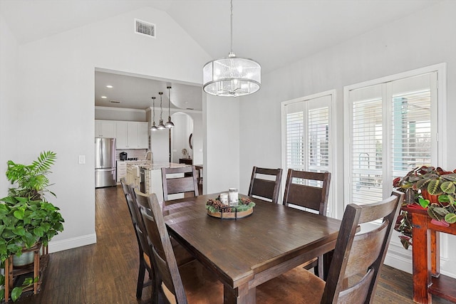 dining room featuring dark hardwood / wood-style floors, a chandelier, and lofted ceiling