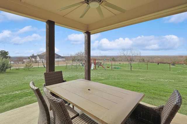 view of patio with a rural view, a playground, and ceiling fan