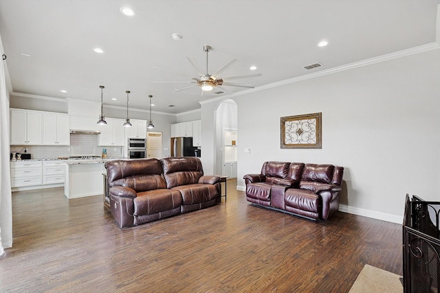 living room featuring ceiling fan, dark hardwood / wood-style flooring, and crown molding