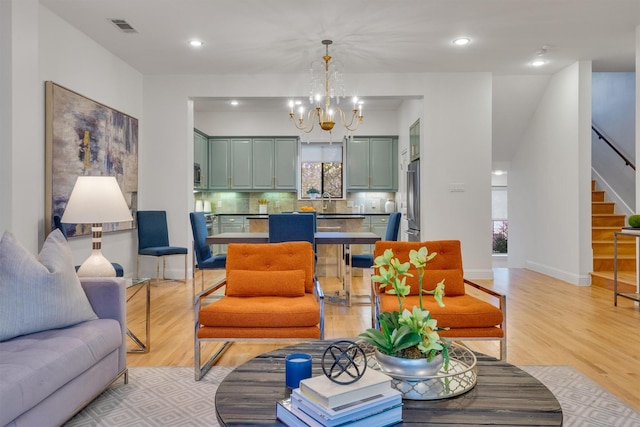 living room featuring light hardwood / wood-style flooring and a notable chandelier