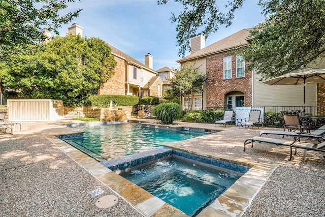 view of swimming pool featuring a patio area and an in ground hot tub