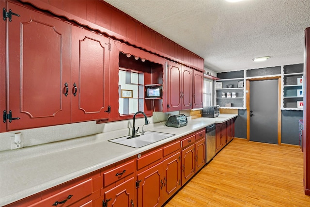 kitchen featuring sink, built in features, stainless steel dishwasher, light hardwood / wood-style floors, and a textured ceiling