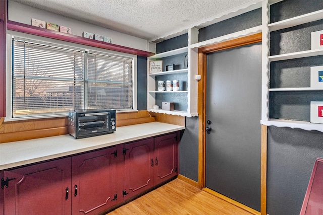 office space featuring a healthy amount of sunlight, light hardwood / wood-style floors, and a textured ceiling