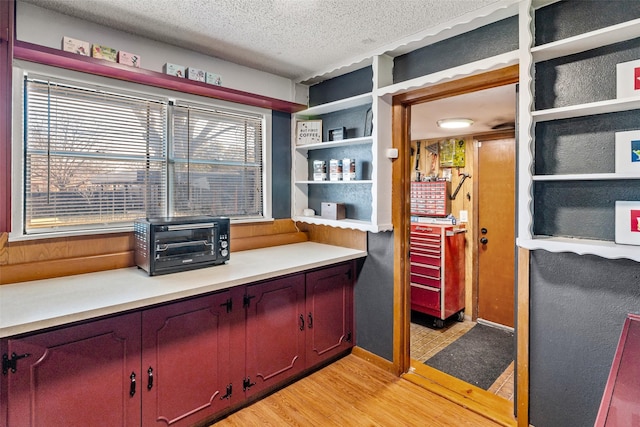 home office featuring a textured ceiling, light hardwood / wood-style floors, and a healthy amount of sunlight