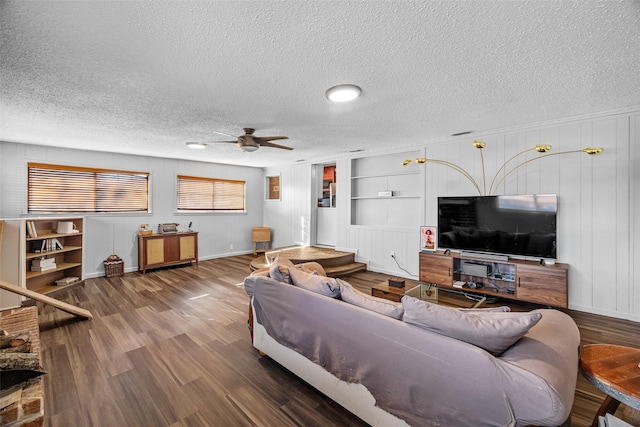 living room featuring ceiling fan, built in features, hardwood / wood-style floors, and a textured ceiling