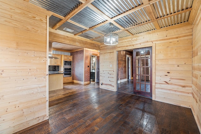 unfurnished room featuring dark hardwood / wood-style floors and wooden walls