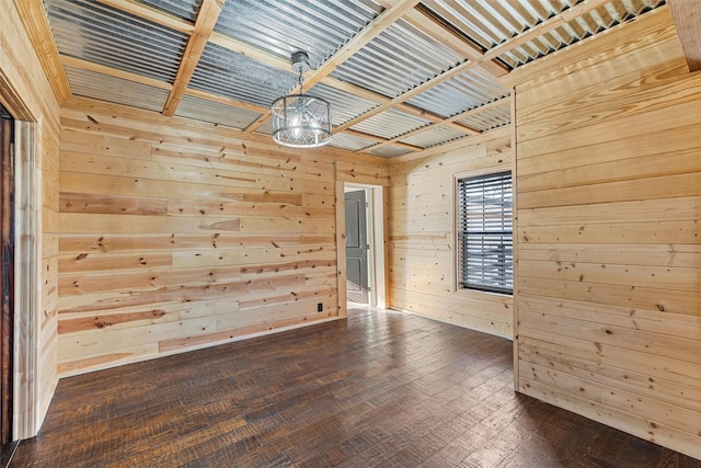 empty room with hardwood / wood-style floors and wood walls