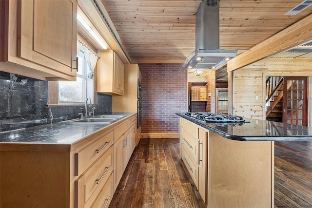 kitchen with light brown cabinetry, stainless steel gas cooktop, sink, a breakfast bar area, and island range hood