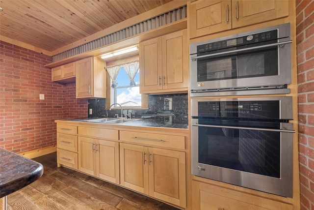 kitchen featuring sink, dark hardwood / wood-style floors, brick wall, and light brown cabinets