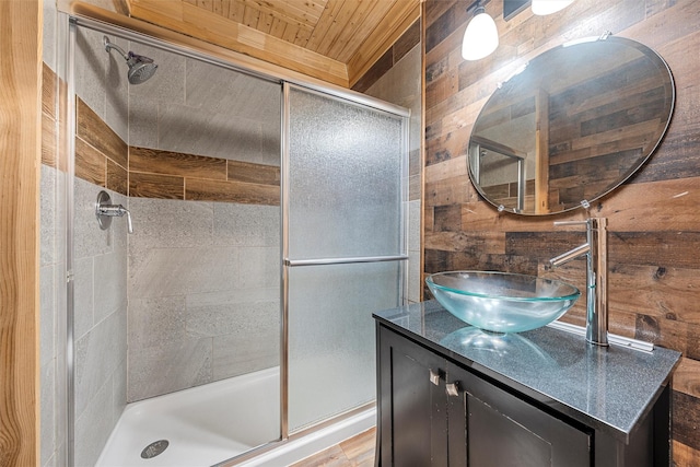 bathroom featuring vanity, a shower with shower door, wood ceiling, and wood walls