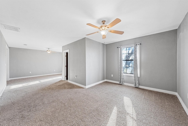 unfurnished room featuring baseboards, ceiling fan, visible vents, and carpet flooring