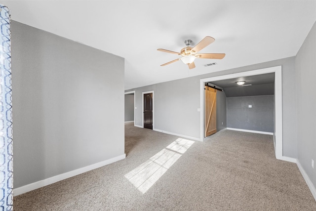 carpeted spare room featuring baseboards, visible vents, and a ceiling fan