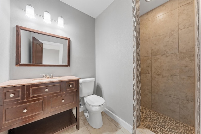 bathroom with tile patterned floors, vanity, toilet, and a tile shower