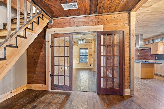 interior space with dark wood-type flooring, wooden walls, and wooden ceiling