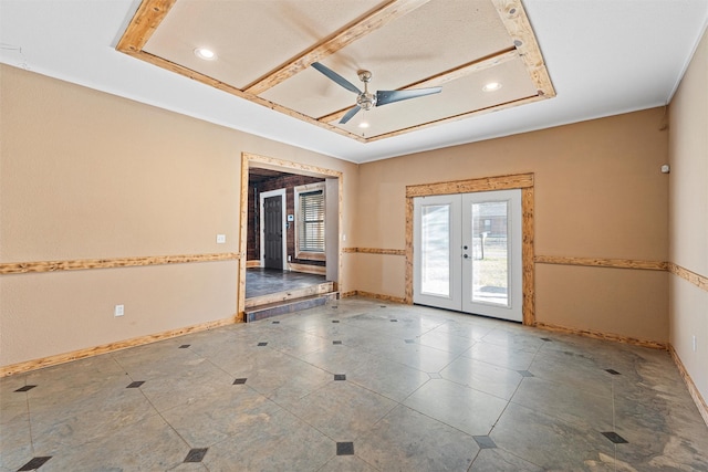 spare room with french doors, a raised ceiling, a ceiling fan, and baseboards