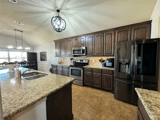 kitchen with stainless steel appliances, hanging light fixtures, sink, and a chandelier