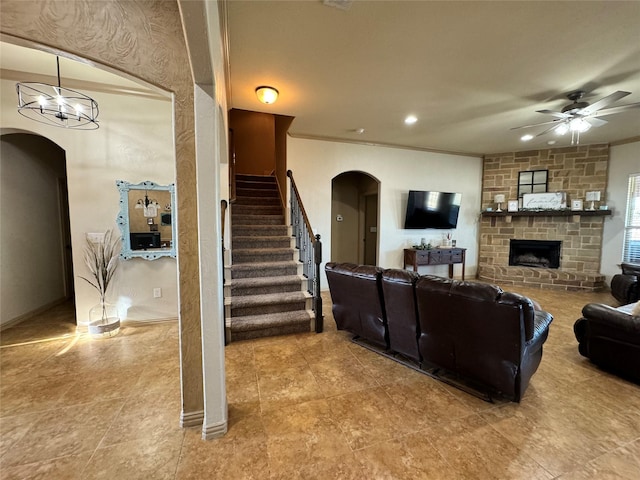 living room with crown molding, a fireplace, and ceiling fan