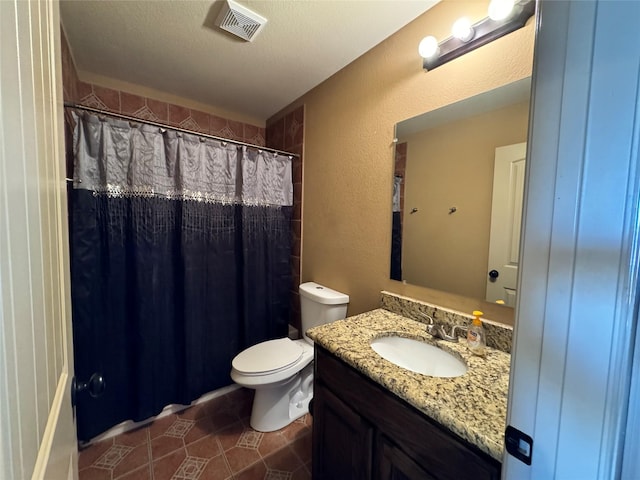 bathroom with vanity, a textured ceiling, tile patterned floors, toilet, and walk in shower