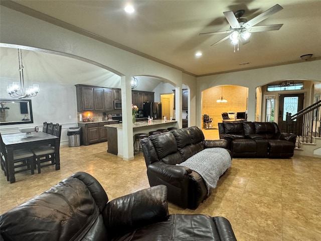 living room featuring crown molding, ceiling fan with notable chandelier, and light tile patterned flooring