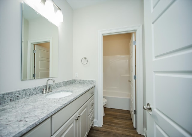 full bathroom featuring hardwood / wood-style flooring, vanity, shower / bath combination, and toilet