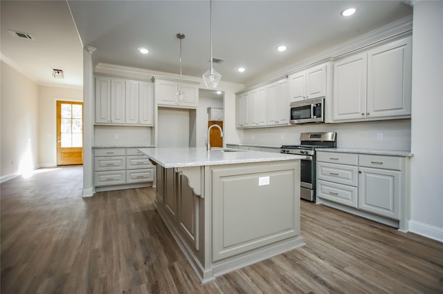 kitchen featuring appliances with stainless steel finishes, pendant lighting, white cabinetry, a kitchen island with sink, and light stone counters