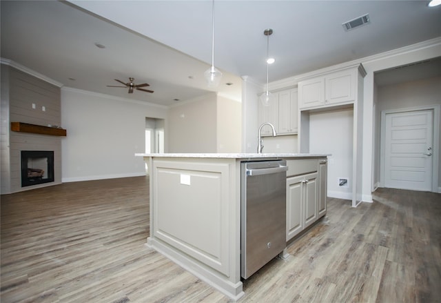 kitchen featuring pendant lighting, crown molding, white cabinetry, a center island with sink, and light wood-type flooring