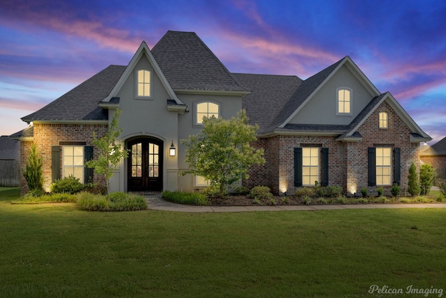 view of front of house featuring french doors and a lawn