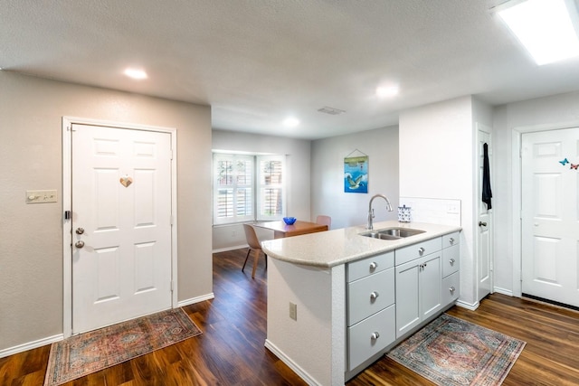 kitchen featuring sink, dark wood-type flooring, and kitchen peninsula