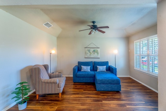 living room featuring ceiling fan, dark hardwood / wood-style floors, and a textured ceiling