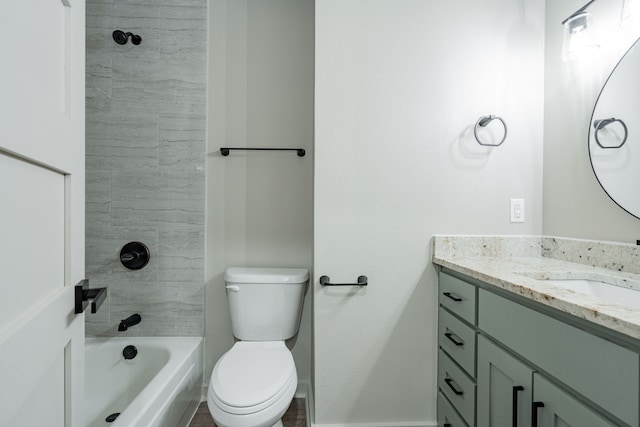 full bathroom featuring vanity, tiled shower / bath, and toilet