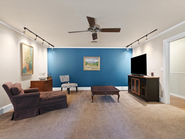 living room with crown molding, light colored carpet, rail lighting, and ceiling fan